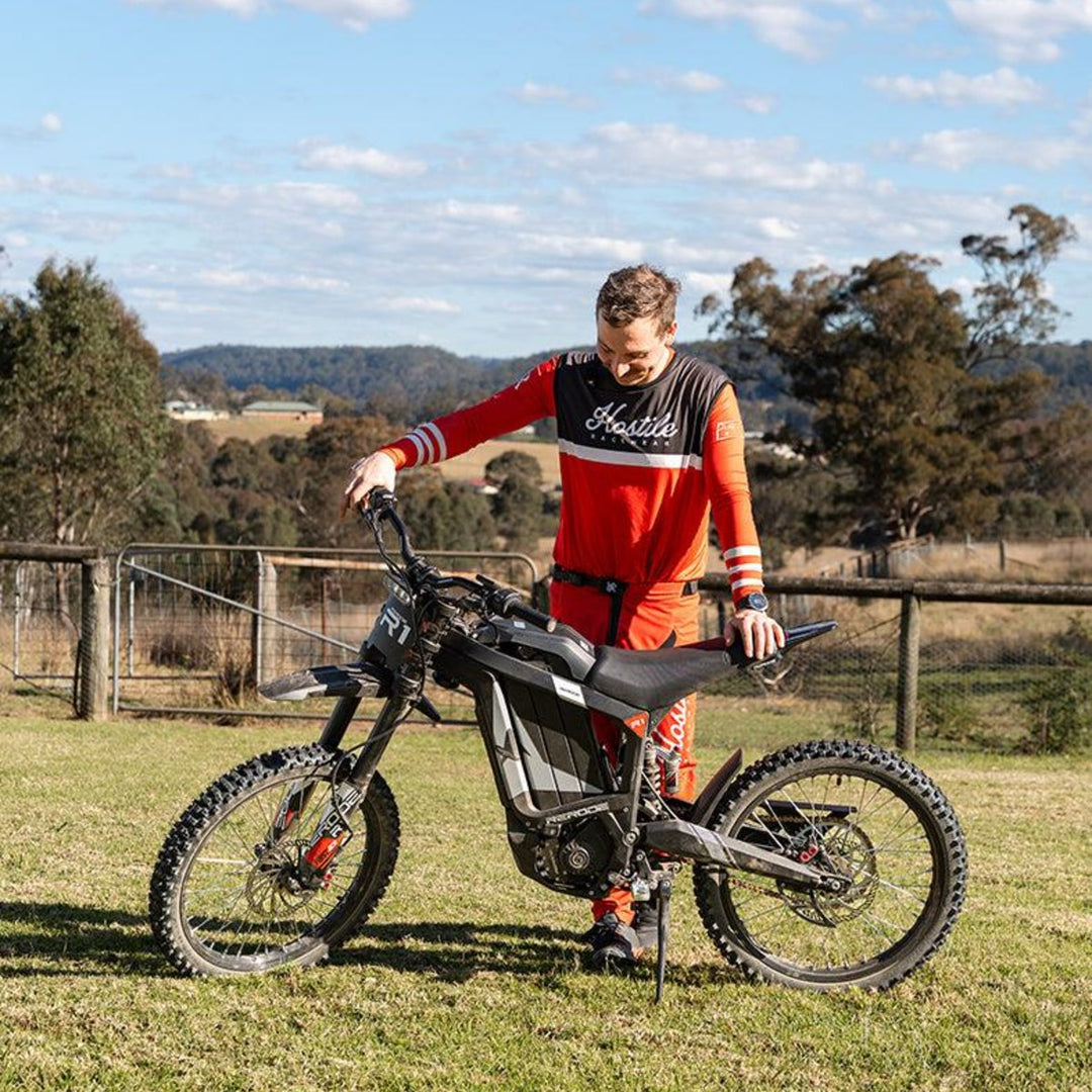 Rider with a Rerode R1 electric dirt bike on a grassy property